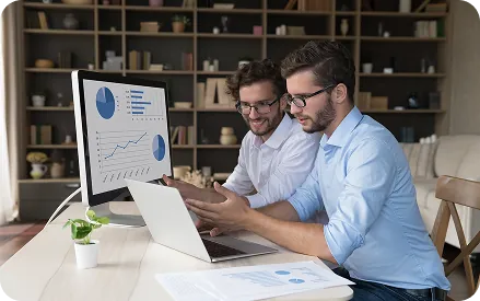 Team reviewing marketing reports on a desktop monitor
